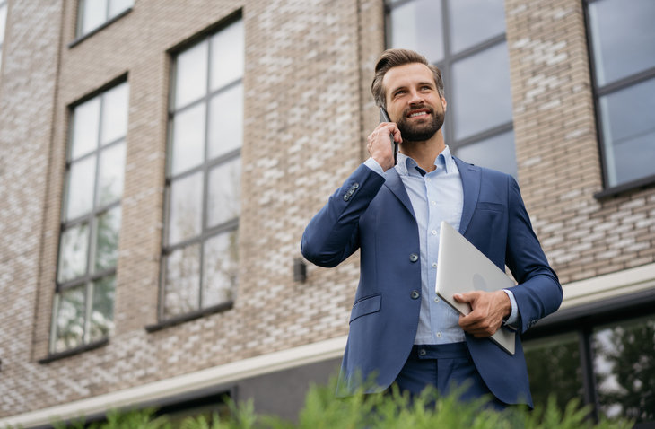 Portrait of an estate agent standing outside his office